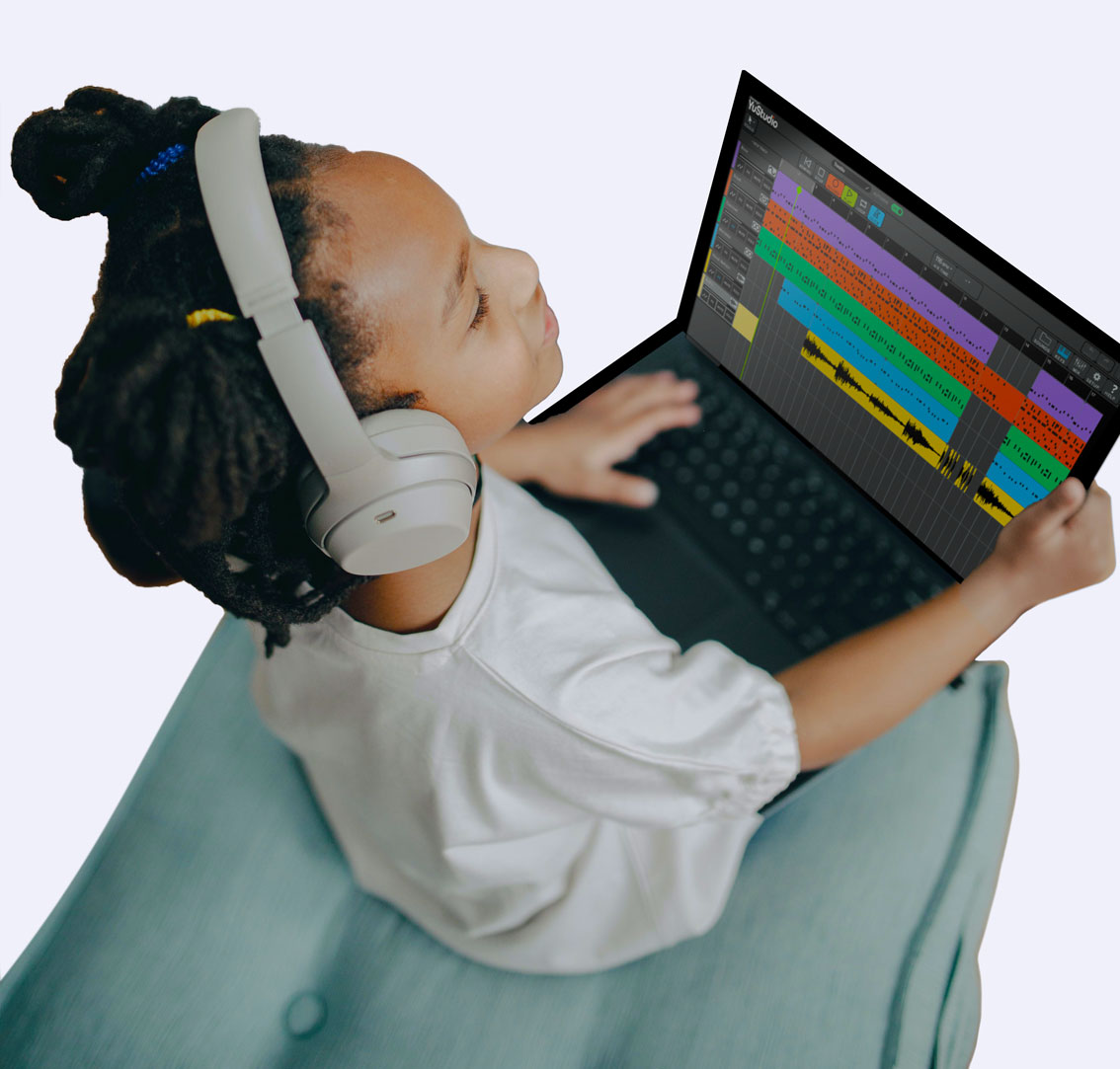 Young girl with headphones on using YuStudio on a laptop